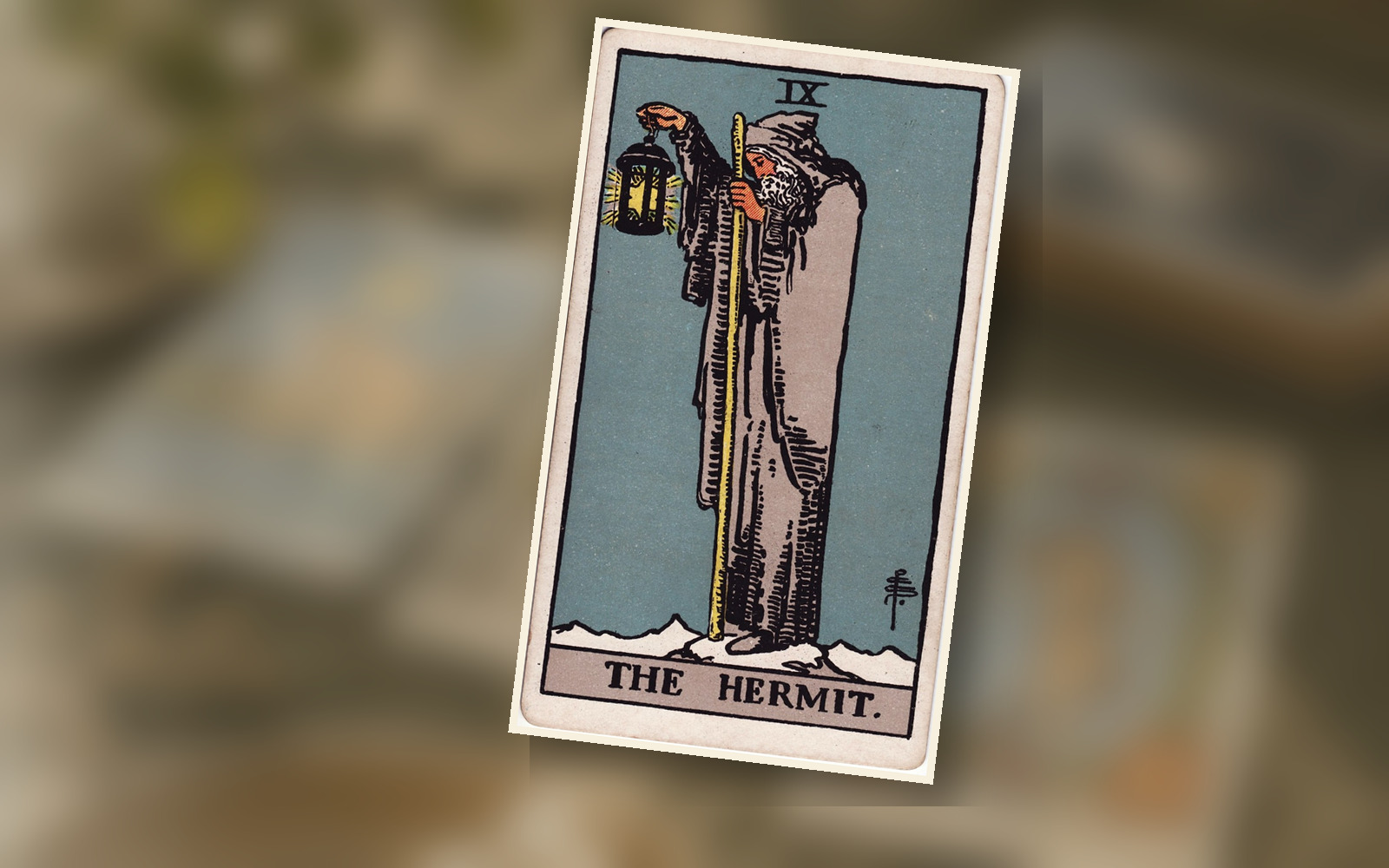 The Hermit tarot card on a wooden table